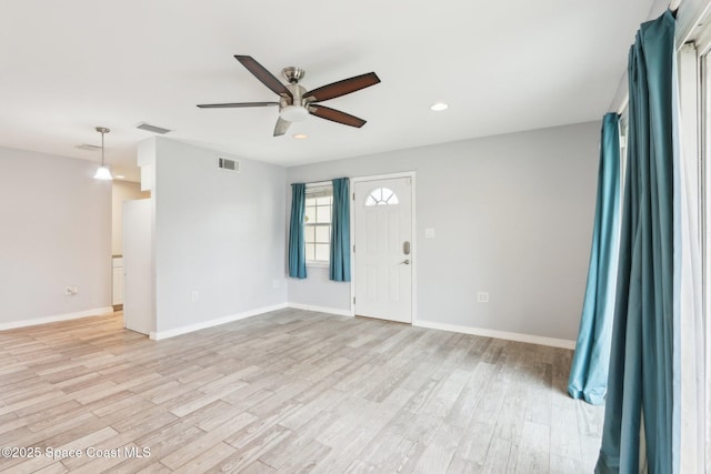 spare room with light wood-type flooring, baseboards, and visible vents