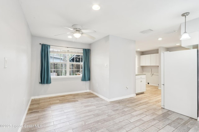 empty room with light wood-type flooring, baseboards, and recessed lighting