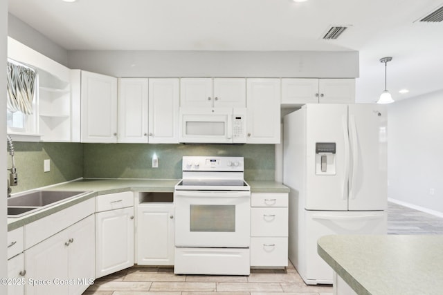 kitchen with pendant lighting, visible vents, white cabinets, a sink, and white appliances