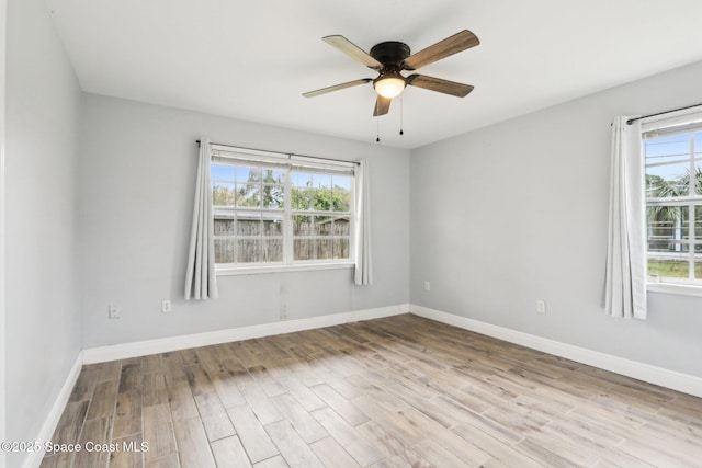 empty room with light wood-type flooring, ceiling fan, and baseboards