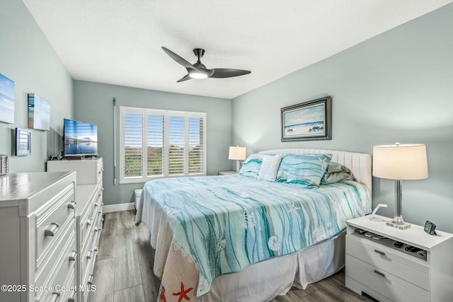 bedroom featuring ceiling fan, light wood-style flooring, and baseboards