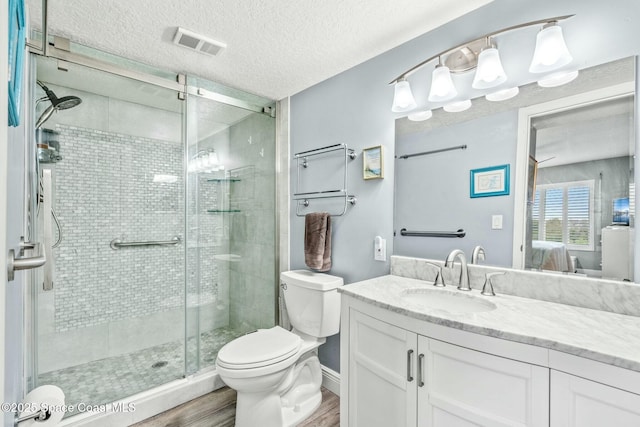 bathroom with ensuite bathroom, toilet, wood finished floors, vanity, and visible vents