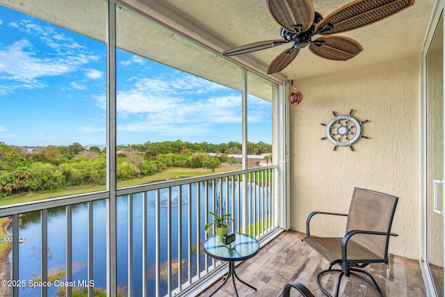 unfurnished sunroom featuring a water view and a ceiling fan