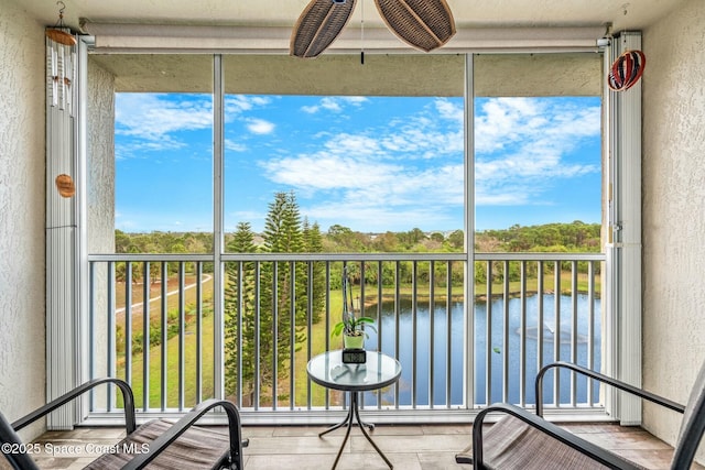 sunroom / solarium featuring a water view and plenty of natural light