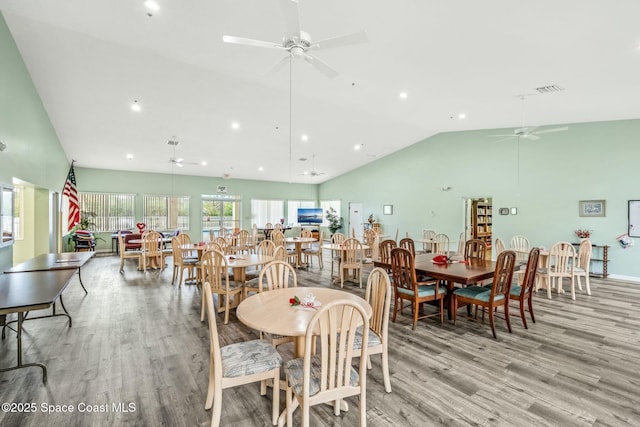 dining space with high vaulted ceiling, light wood-style flooring, visible vents, and ceiling fan