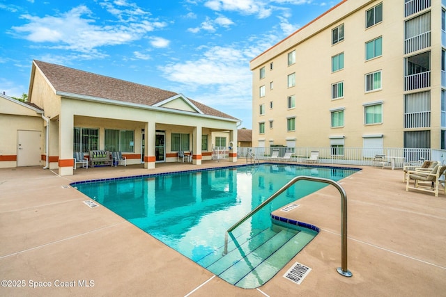 community pool featuring a patio area and fence