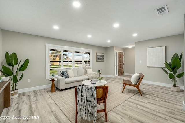 living room with recessed lighting, light wood-type flooring, visible vents, and baseboards