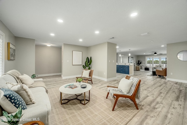 living area featuring light wood finished floors, baseboards, visible vents, and recessed lighting