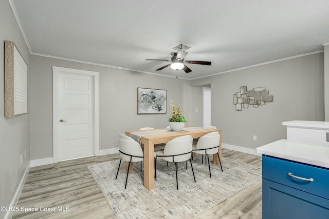 dining space featuring light wood-style floors and crown molding