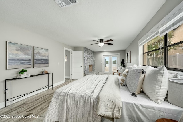 bedroom with visible vents, baseboards, access to outside, french doors, and light wood finished floors