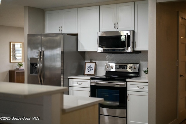 kitchen with white cabinets, appliances with stainless steel finishes, light countertops, and decorative backsplash