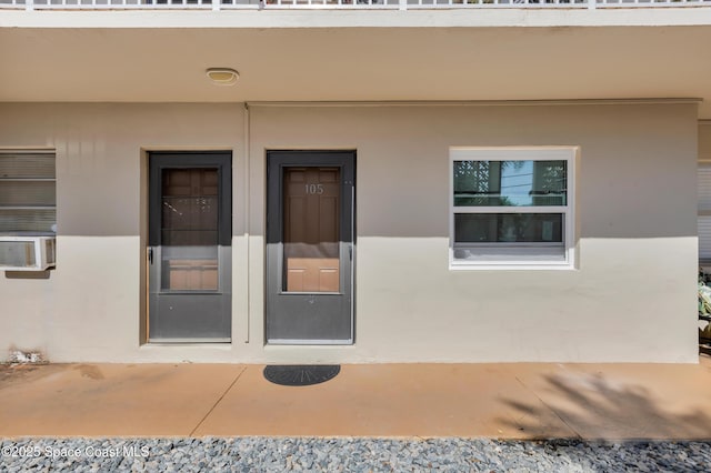 doorway to property with a patio and stucco siding