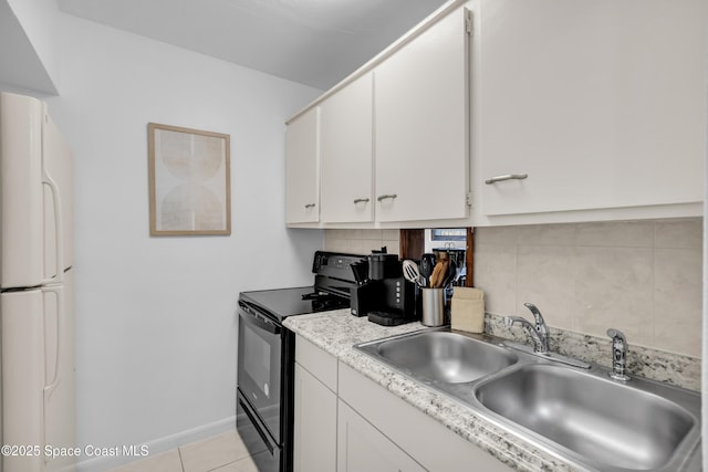 kitchen with black electric range, white cabinetry, a sink, and freestanding refrigerator