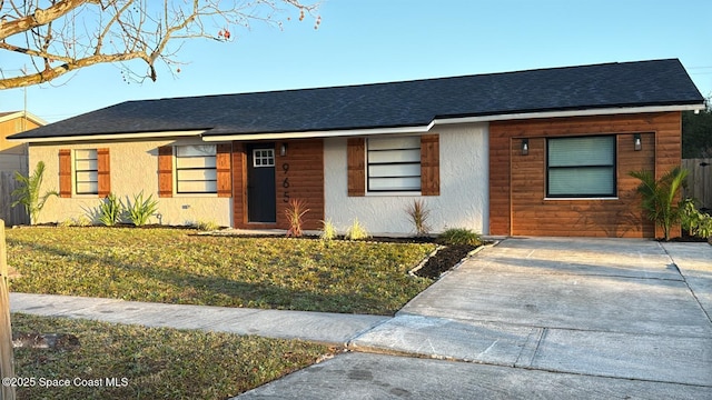 single story home with stucco siding, a shingled roof, and a front yard