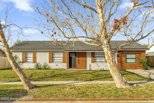 ranch-style house featuring fence, stucco siding, and a front yard