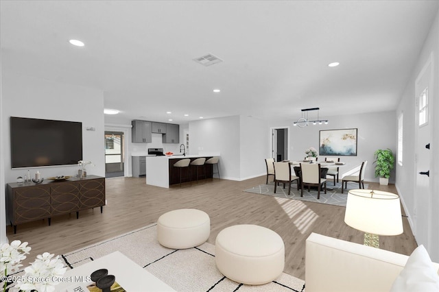 living room with recessed lighting, a healthy amount of sunlight, and light wood-style floors