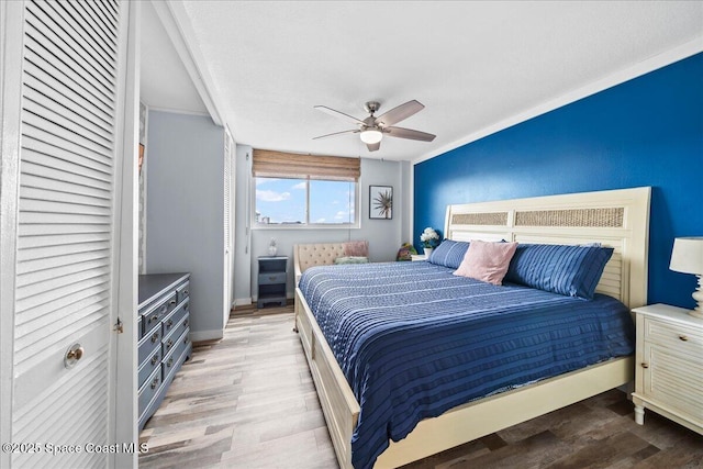 bedroom featuring baseboards, light wood-style flooring, and a ceiling fan