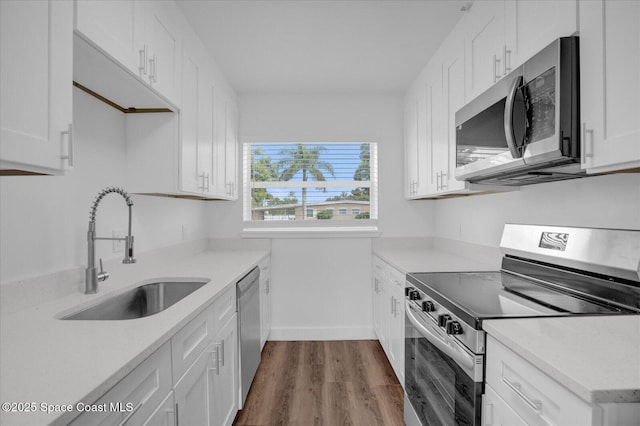 kitchen with white cabinetry, appliances with stainless steel finishes, light countertops, and a sink