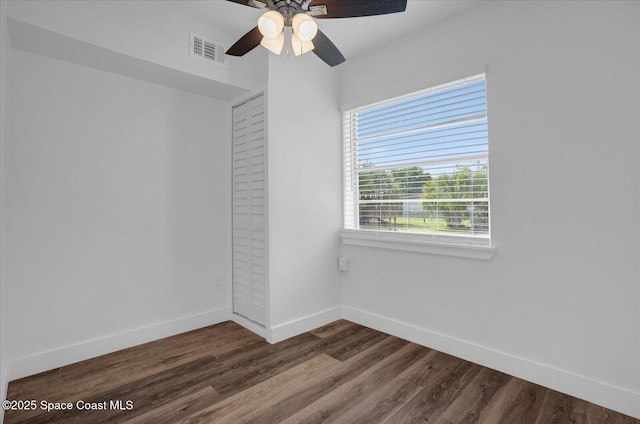 unfurnished room featuring a ceiling fan, baseboards, visible vents, and wood finished floors