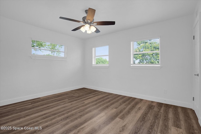 unfurnished room with dark wood-style floors, ceiling fan, and baseboards