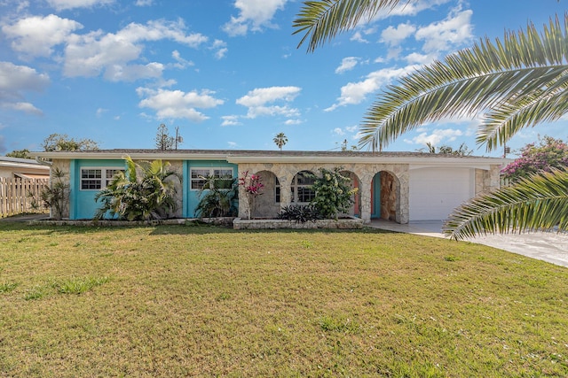 ranch-style house with driveway, stone siding, an attached garage, and a front lawn