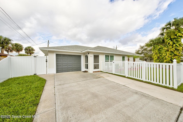 view of front facade featuring stucco siding, concrete driveway, a front yard, a garage, and fence private yard