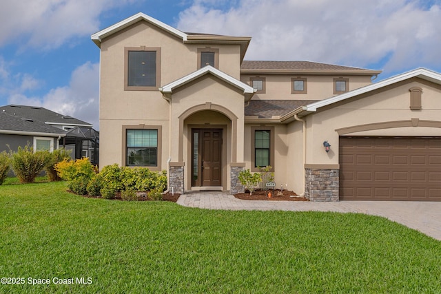 view of front of house featuring stone siding, an attached garage, decorative driveway, a front lawn, and stucco siding