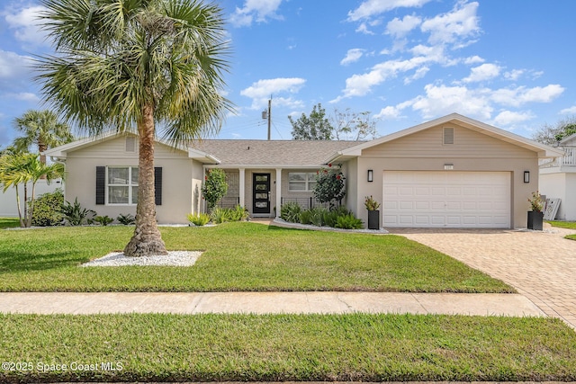 view of front of house with a garage, a front yard, decorative driveway, and stucco siding