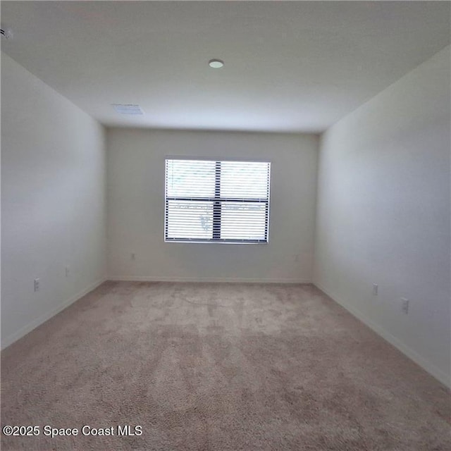 empty room with light colored carpet and baseboards