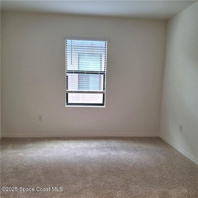 unfurnished room with carpet and baseboards