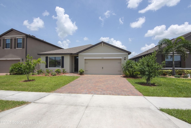 1923 Capital Dr SE, Palm Bay, FL 32909 - view of front facade with decorative driveway, a front lawn, stucco siding, and a garage