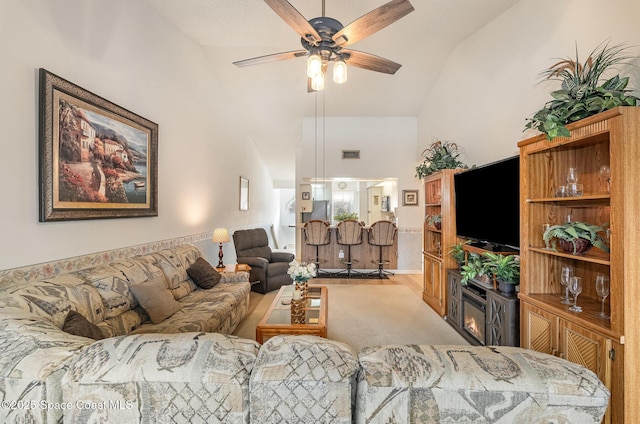 living room featuring high vaulted ceiling, light colored carpet, visible vents, and a ceiling fan