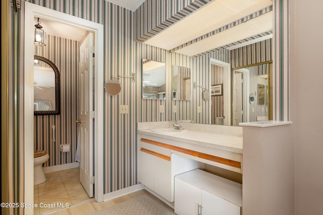 bathroom with tile patterned flooring, vanity, toilet, and wallpapered walls