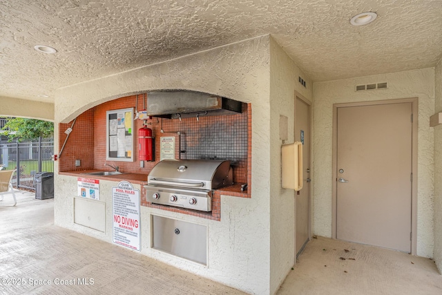 view of patio / terrace featuring visible vents, a grill, fence, exterior kitchen, and a sink