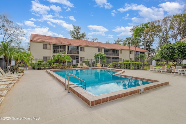 community pool featuring a patio and fence