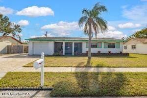 ranch-style home with an attached garage, concrete driveway, and a front yard