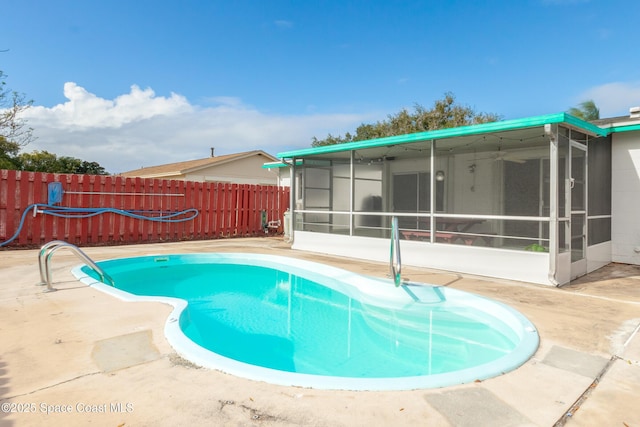 view of swimming pool featuring a sunroom, a fenced backyard, a fenced in pool, and a patio