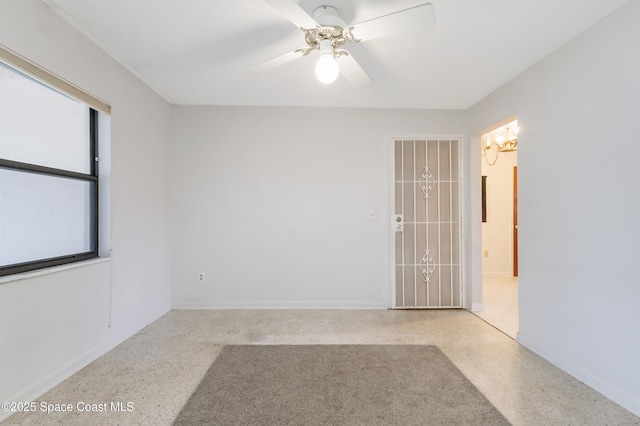 unfurnished room featuring ceiling fan, baseboards, and light speckled floor