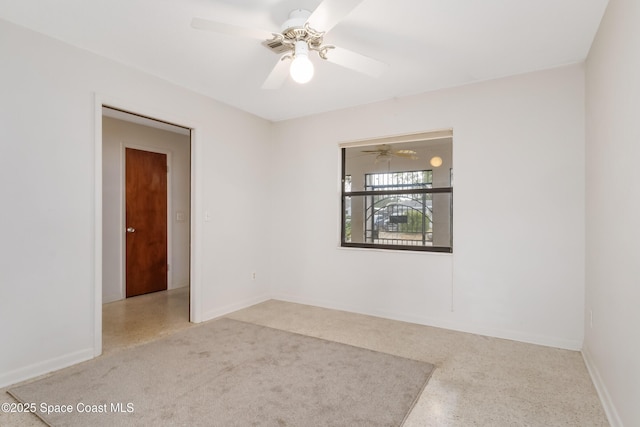 unfurnished room with baseboards, light speckled floor, and a ceiling fan