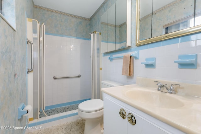 bathroom with speckled floor, a stall shower, tile walls, and wallpapered walls