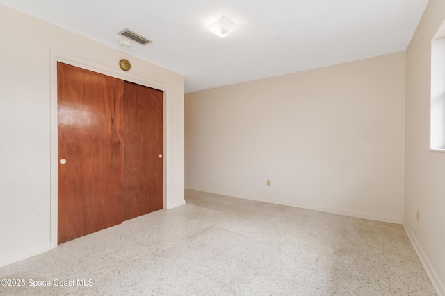 empty room featuring visible vents and speckled floor