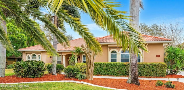 mediterranean / spanish-style house with a tiled roof and stucco siding