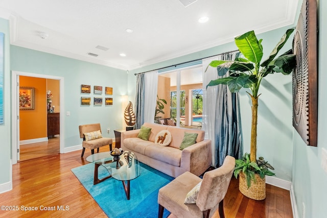 living area with light wood-style flooring, baseboards, and crown molding