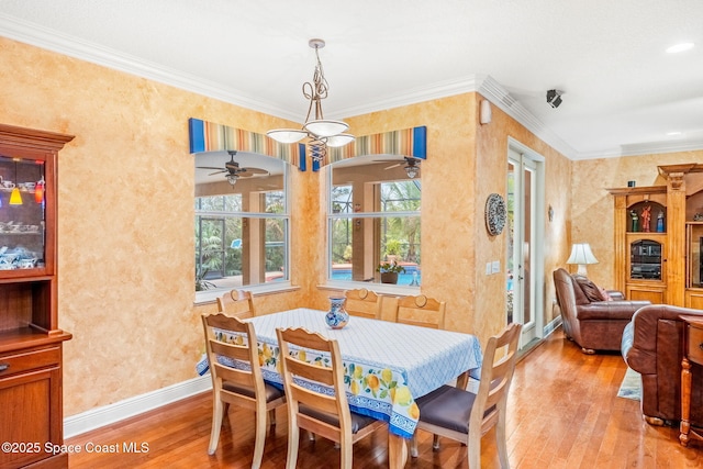 dining area with light wood finished floors, baseboards, and ornamental molding