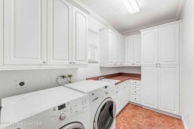 washroom featuring cabinet space, washer and clothes dryer, crown molding, a textured ceiling, and a sink