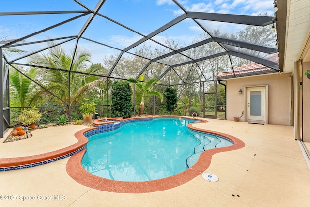 view of pool with a patio area, glass enclosure, and a pool with connected hot tub