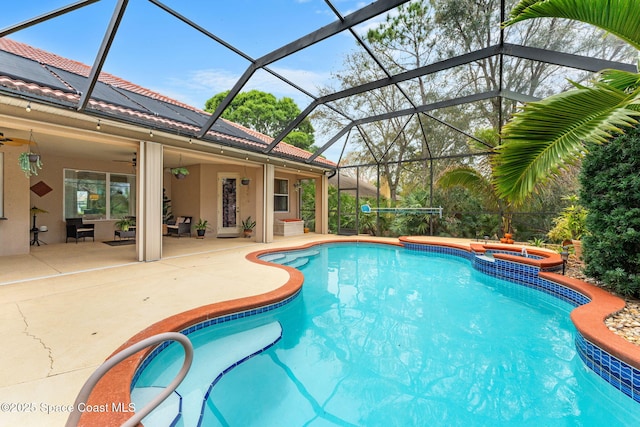 view of pool featuring a lanai, ceiling fan, a pool with connected hot tub, and a patio