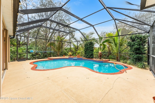 view of swimming pool featuring glass enclosure, a pool with connected hot tub, and a patio area