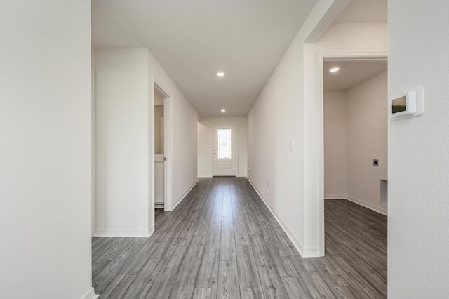 hallway with light wood-type flooring, baseboards, and recessed lighting