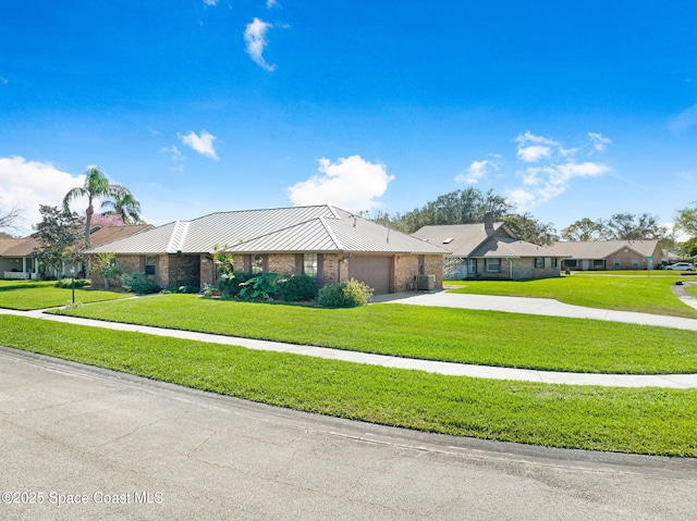 ranch-style home with brick siding, concrete driveway, central AC unit, metal roof, and a garage